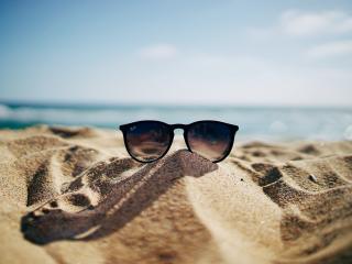 Sunglasses on sand at beach. Photo by Ethan Robertson on Unsplash