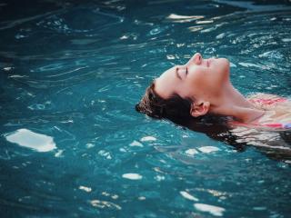 Woman floating on body of water. Photo by Haley Phelps on Unsplash
