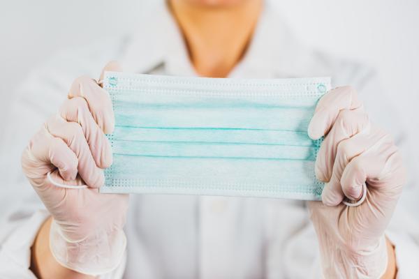 Healthcare worker holding a surgical mask
